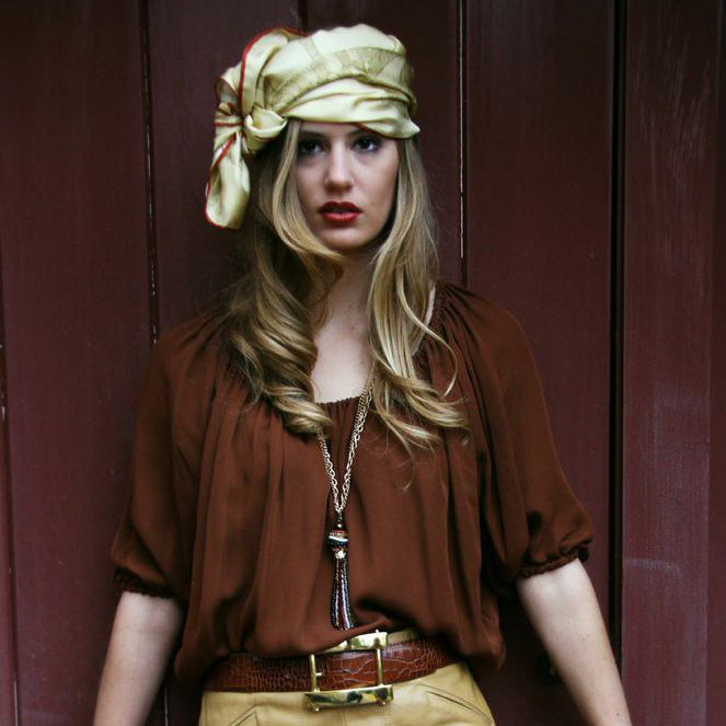 Model wearing Chetna Singh gold tone horse print square silk scarf.