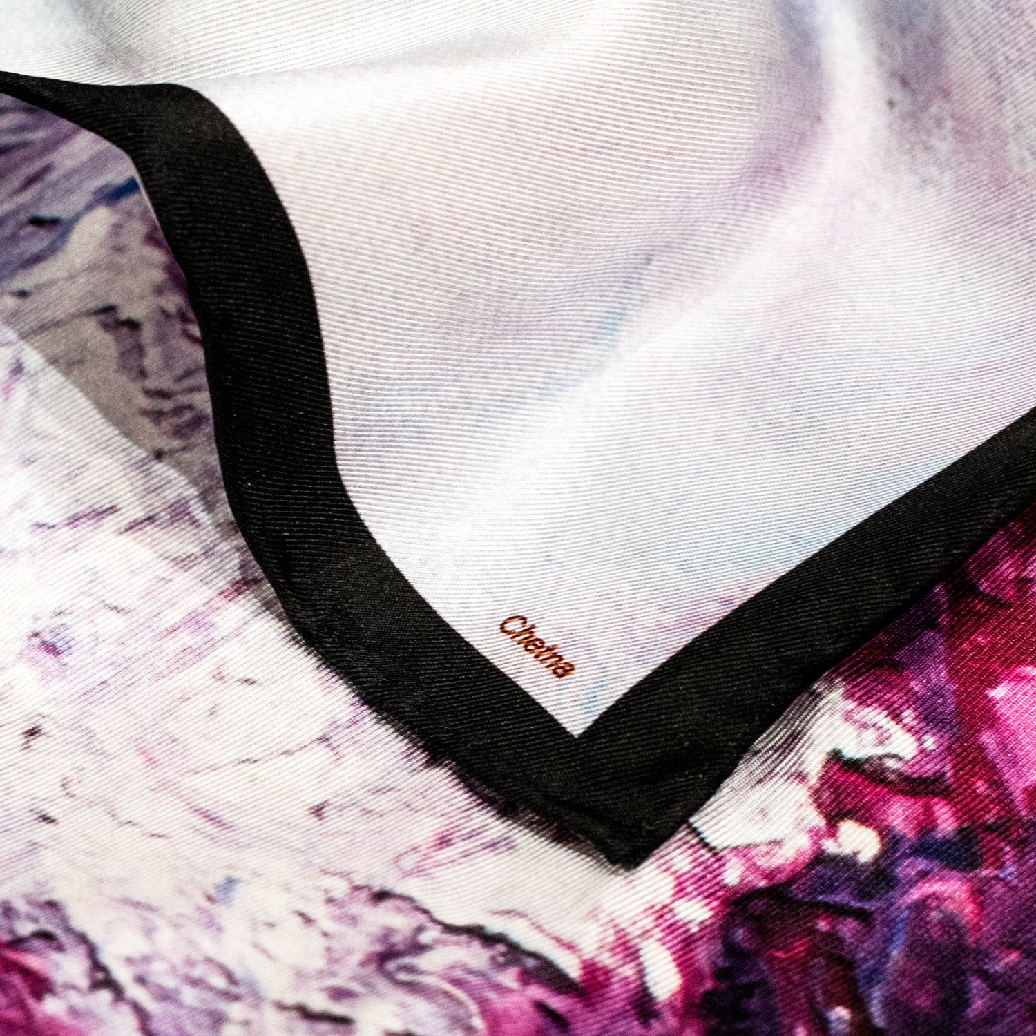 Close-up of Chetna Singh white and purple horse print square silk scarf.