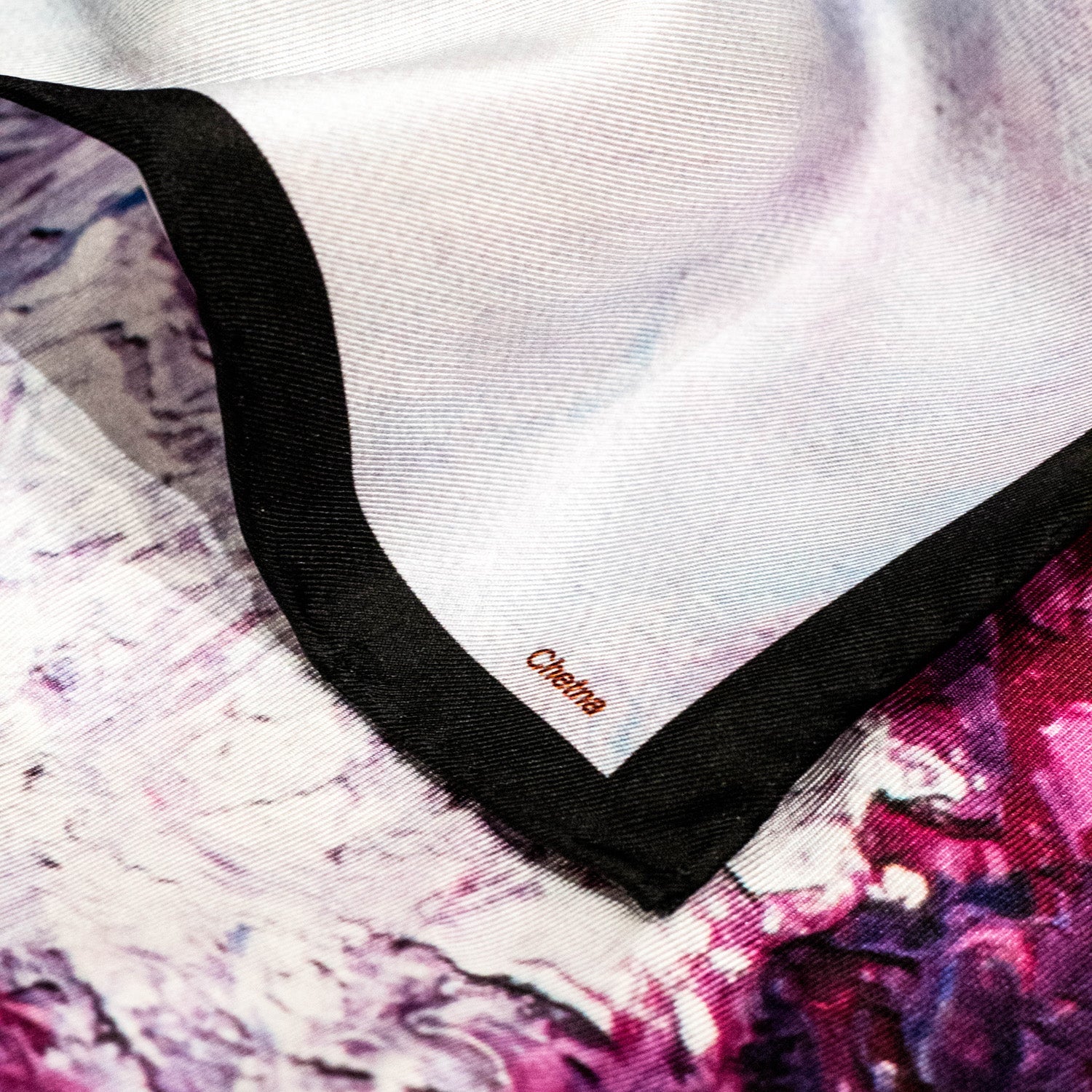 Close-up of Chetna Singh white and purple horse print square silk scarf. 