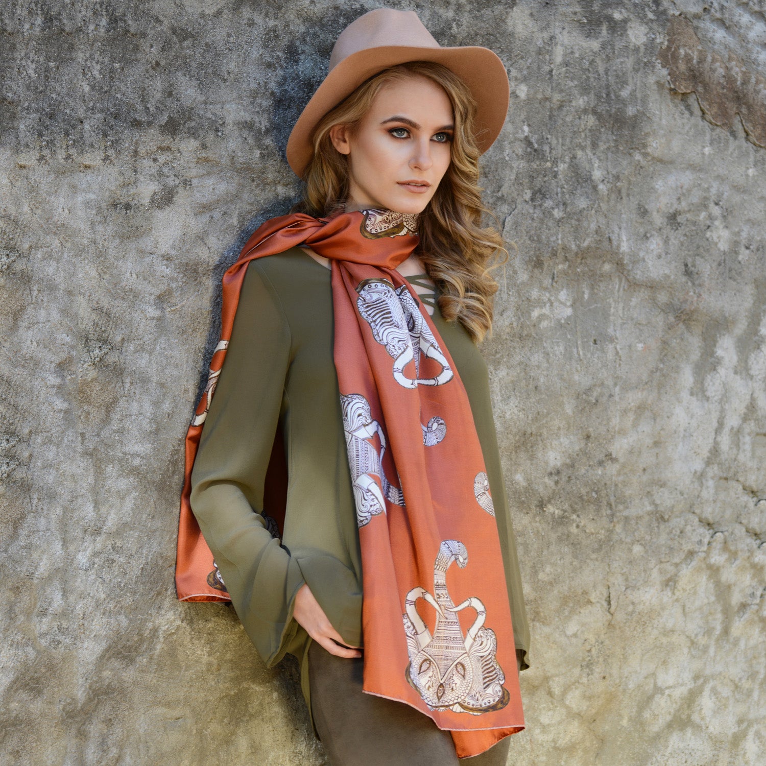 Model wearing Chetna Singh orange and rust tone elephant print long silk scarf. 