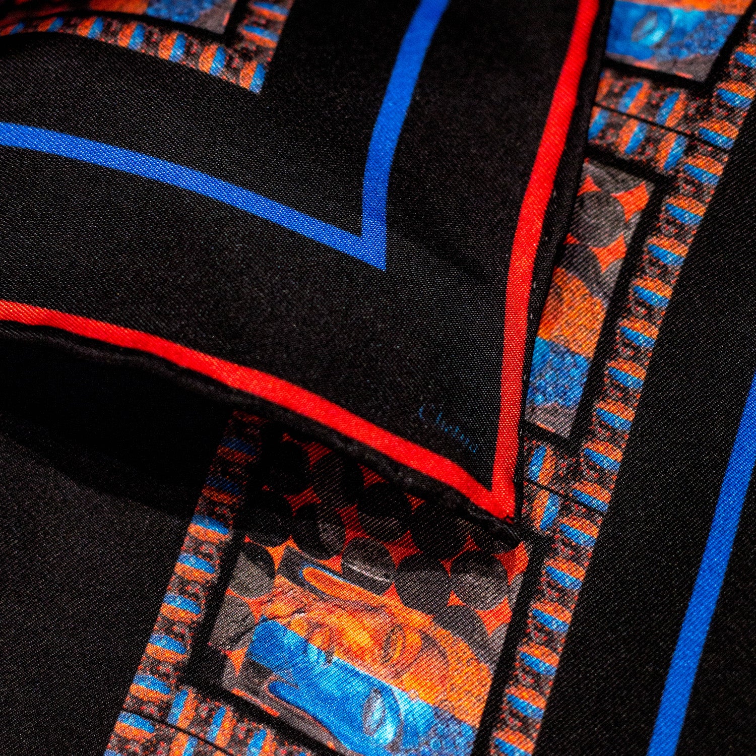 Close-up of Chetna Singh black silk scarf with Buddha print trim. 