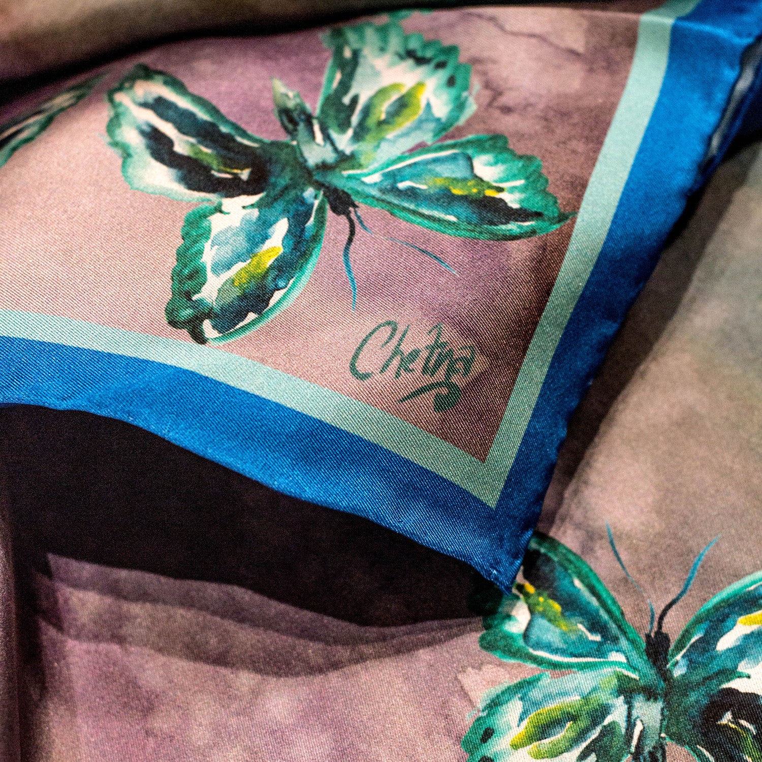 Close-up of Chetna Singh jewel tone butterfly print long silk scarf. 